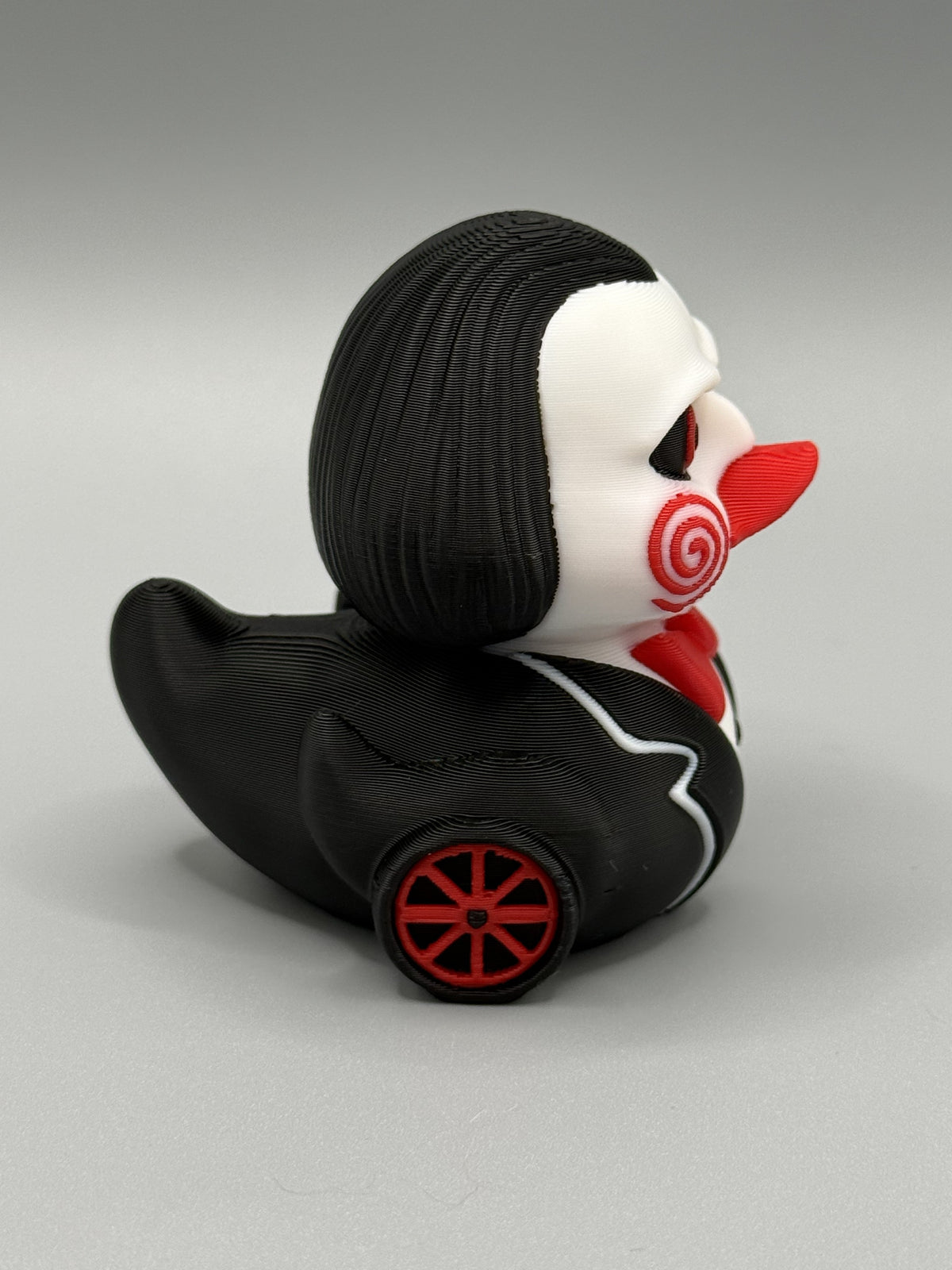 Billy the Puppet Duck side view showing red tricycle wheel