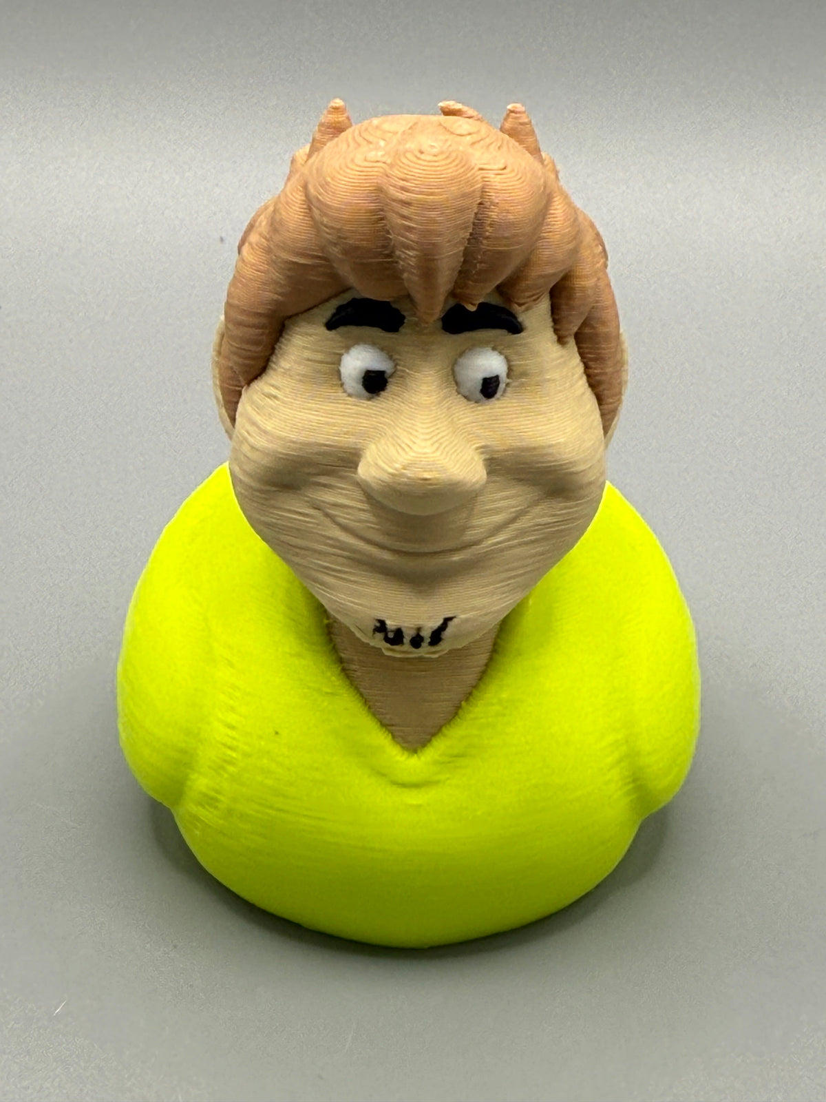 Shaggy Duck – front view showing wild brown hair, wide eyes, stubble, and bright yellow-green shirt