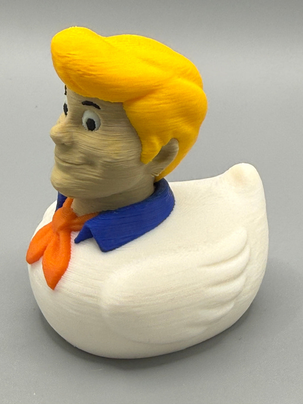 Fred Duck – side view showing golden yellow hair, blue collar, orange ascot, and white duck body