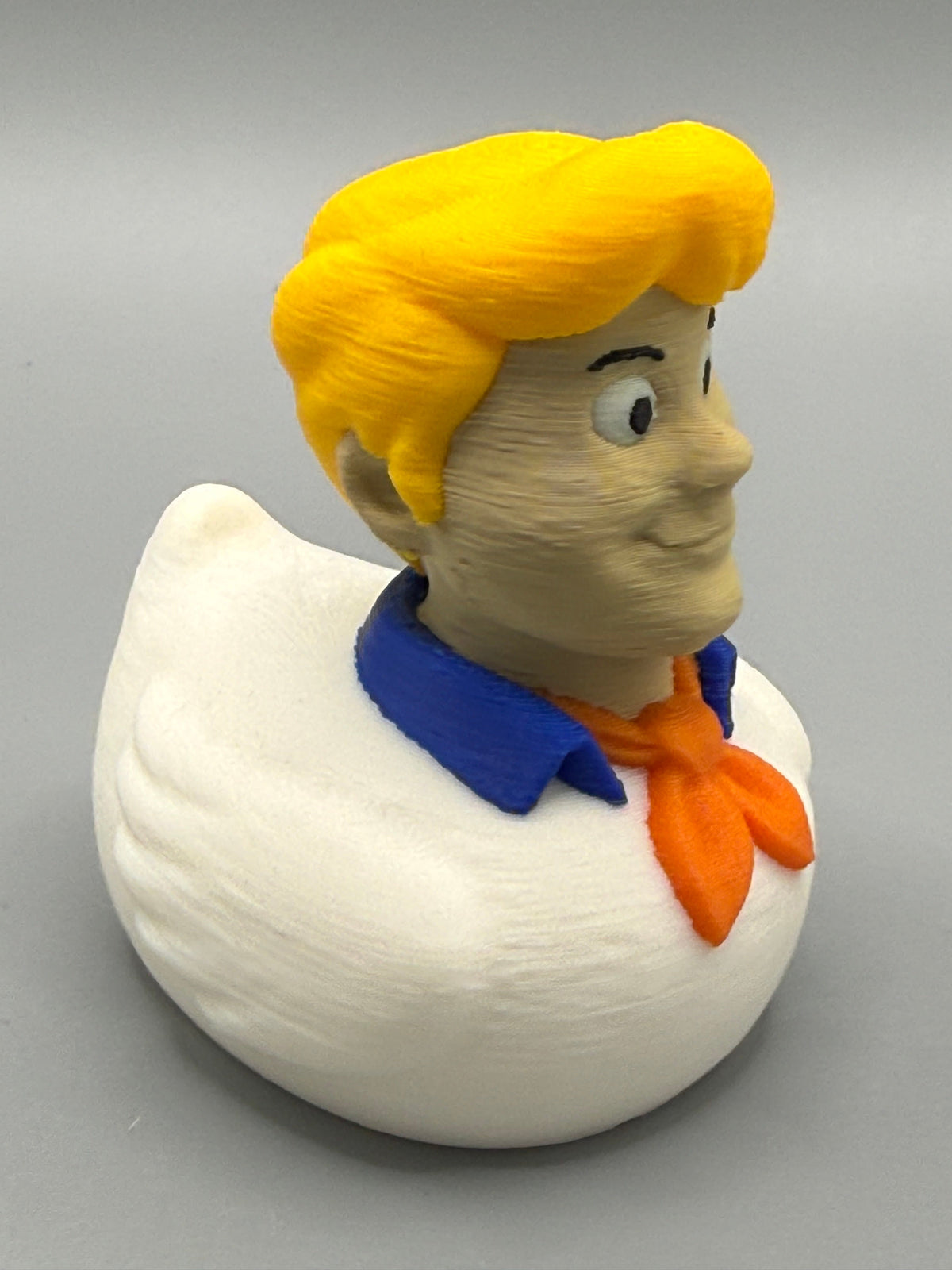 Fred Duck – opposite side view showing sculpted yellow hair and white PLA body with orange ascot